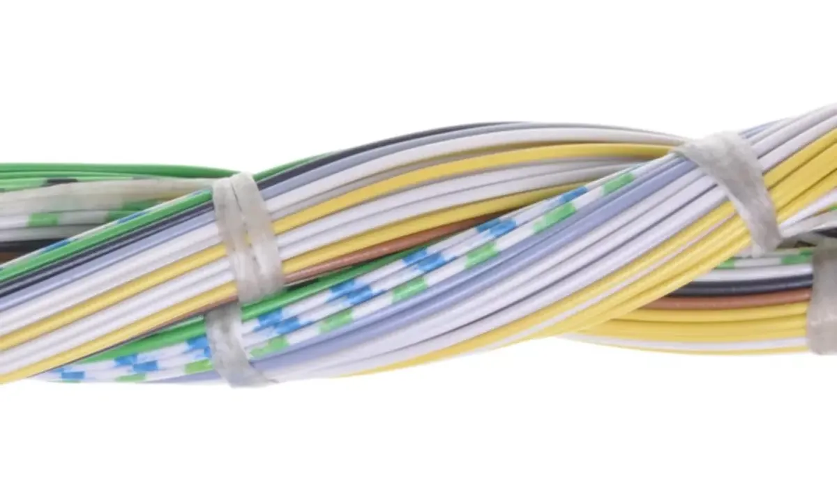 Close-up of twisted green, yellow, and white wires bundled with two zip ties on a plain white background.
