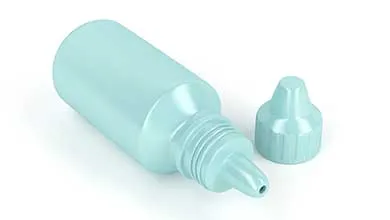 Light blue plastic dropper bottle, uncapped, lying on its side next to its cap on a white background.