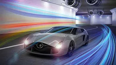 A sleek silver sports car with headlights on speeds through a modern tunnel, colorful light trails blurring behind to show motion.