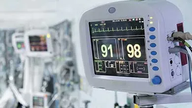 Close-up of a white ultrasound transducer resting on an ultrasound machine’s control panel.